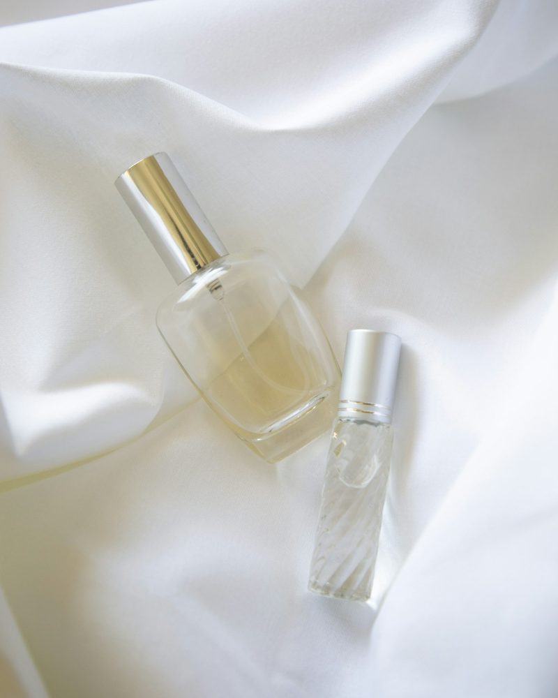 Glass fragrance bottles resting on soft fabric